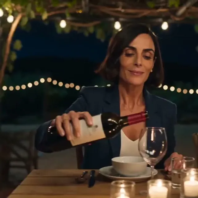 One person sharing a dinner table with several alternate versions of themselves